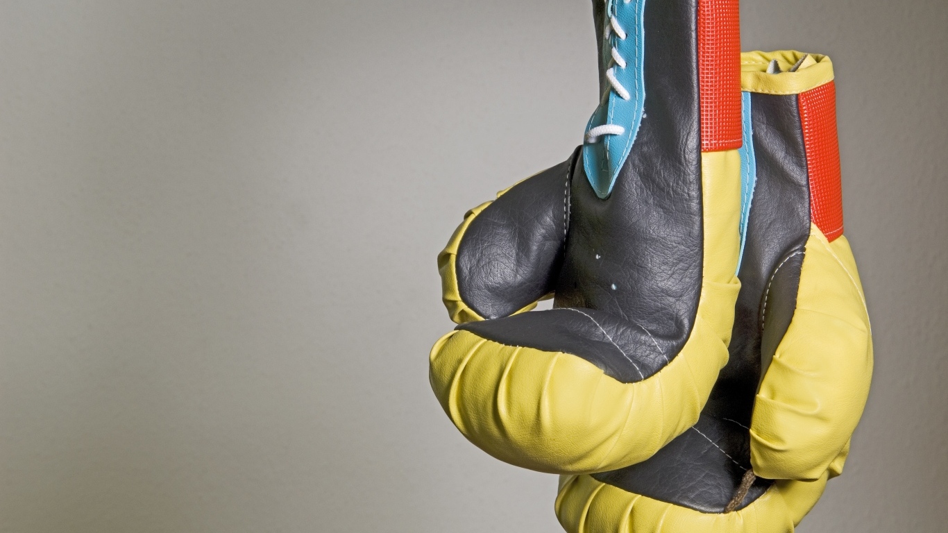 Боксерские перчатки на фоне серой стены 