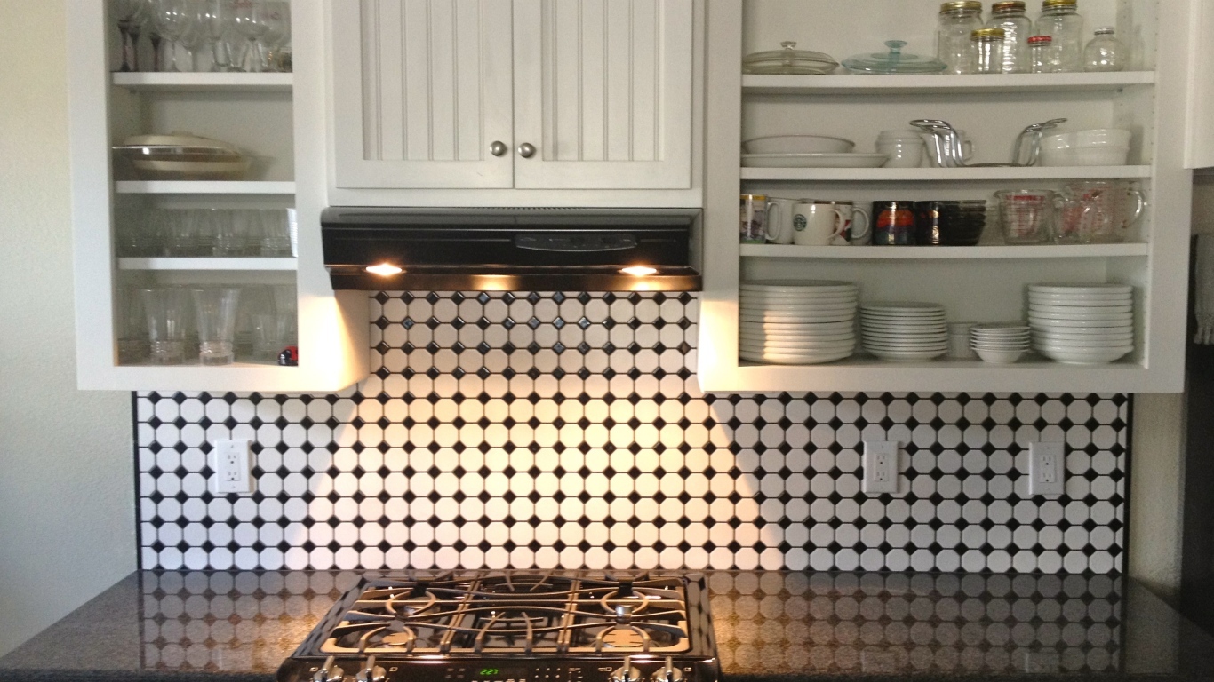 Электрическая плита в кухне с белым гарнитуром