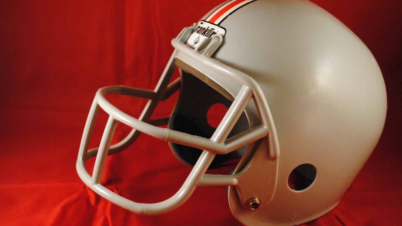 Шлем для игры в американский футбол на красном фоне