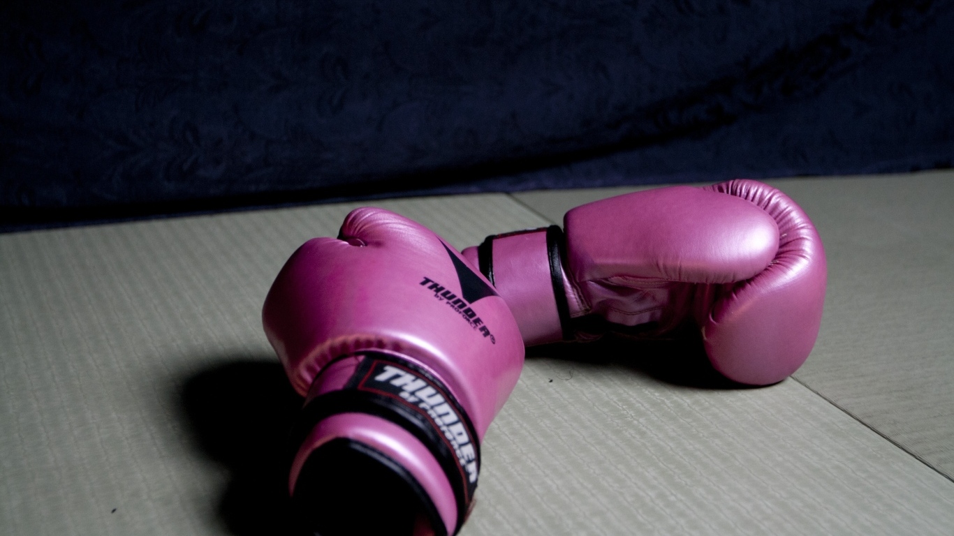 Розовые боксерские перчатки на столе 