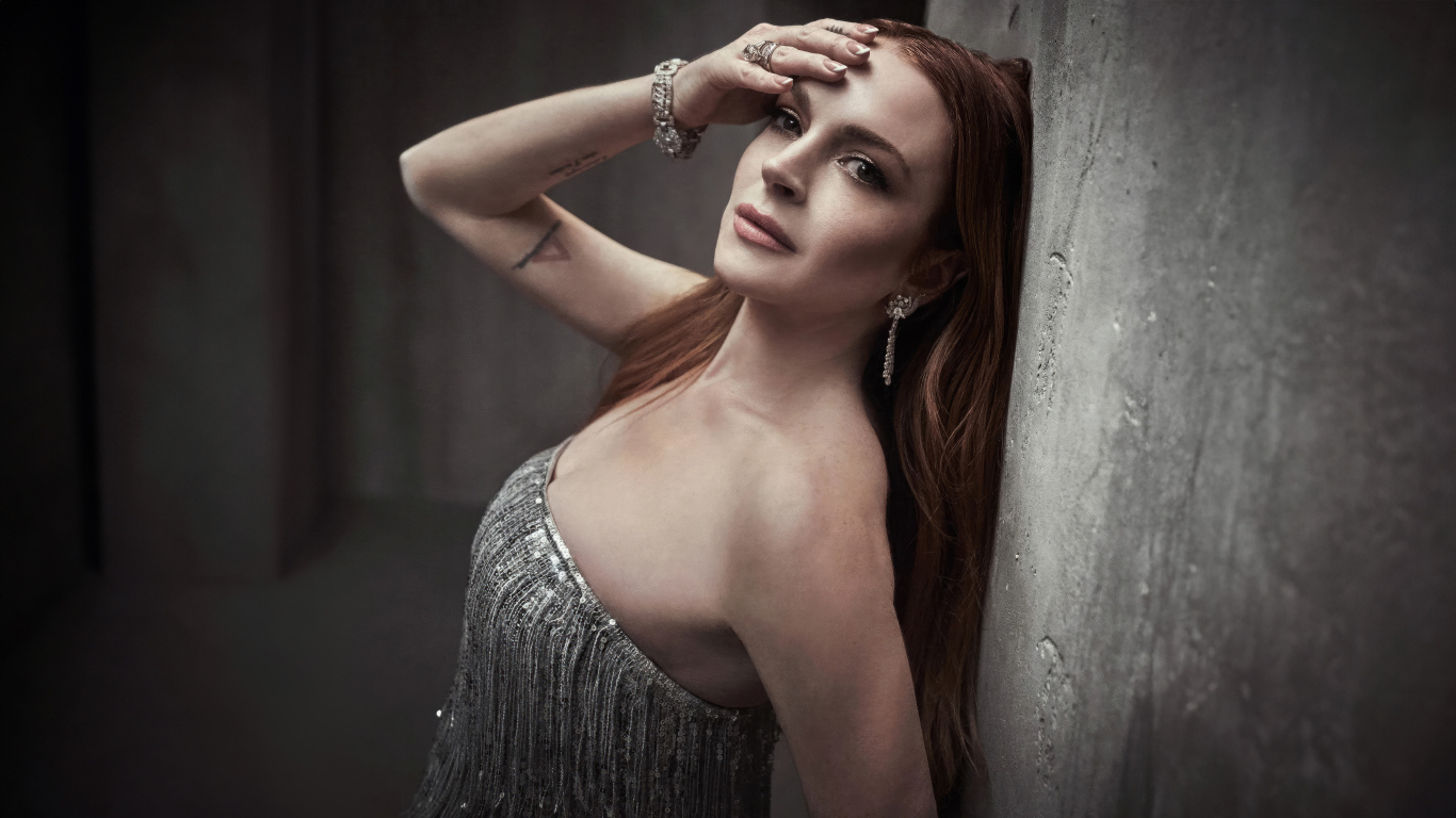 Рыжеволосая актриса Линдси Лохан стоит у стены