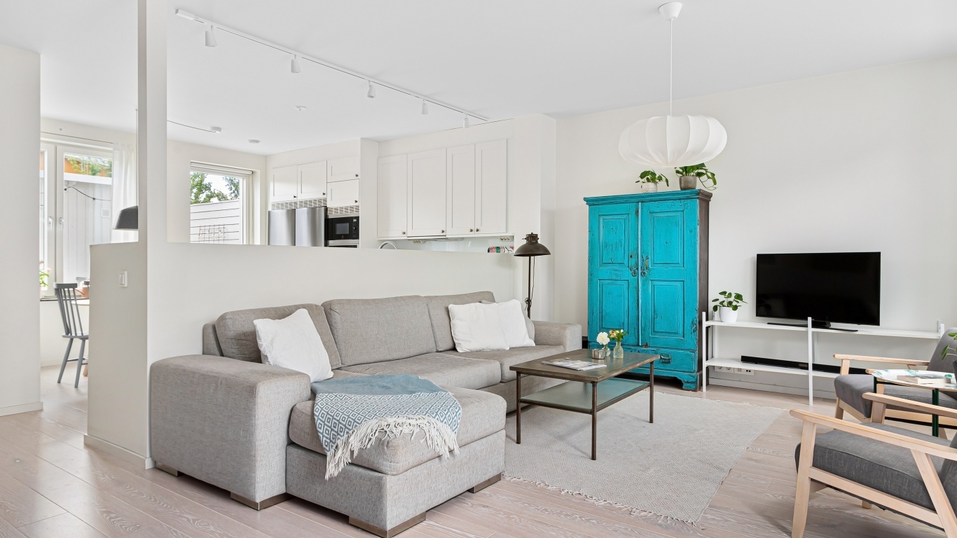 Просторная гостиная комната  с серым диваном