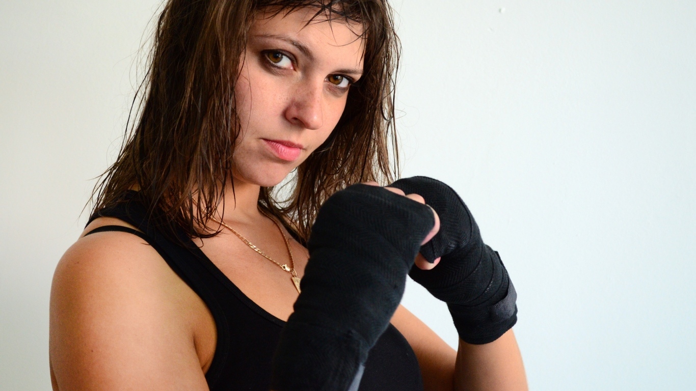 Девушка стоит в спортивной  стойке 