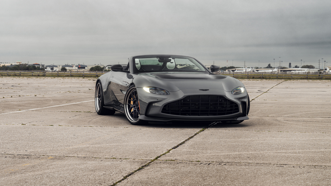 Серый автомобиль Aston Martin Vantage V12 Roadster на взлетной полосе