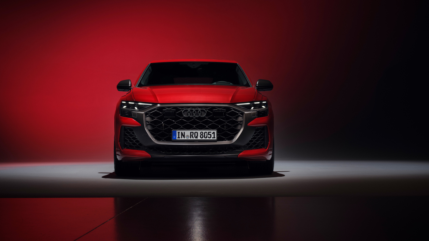 Вид спереди на автомобиль Audi RS Q8 performance 2024 года на красном фоне
