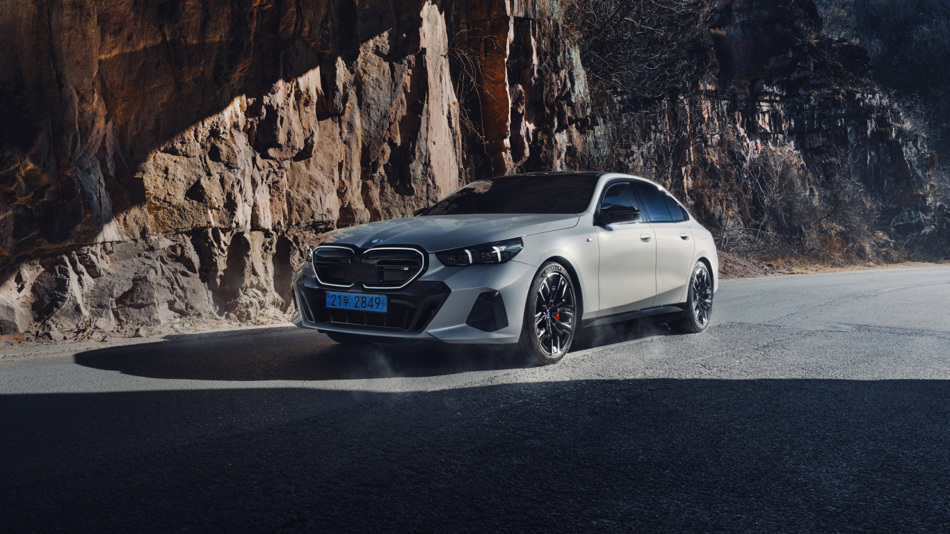 Серебристый автомобиль BMW i5 M60 у горы