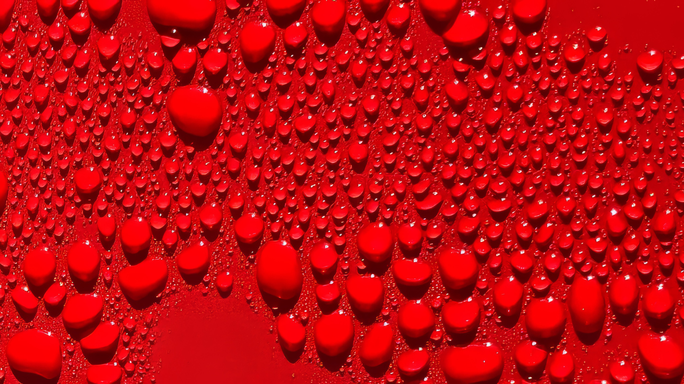 Капли воды на ярком красном фоне