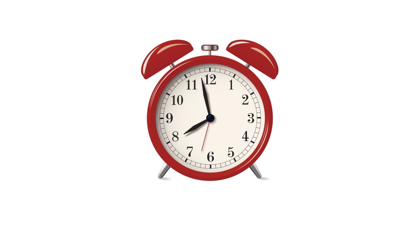 Красный будильник на белом фоне