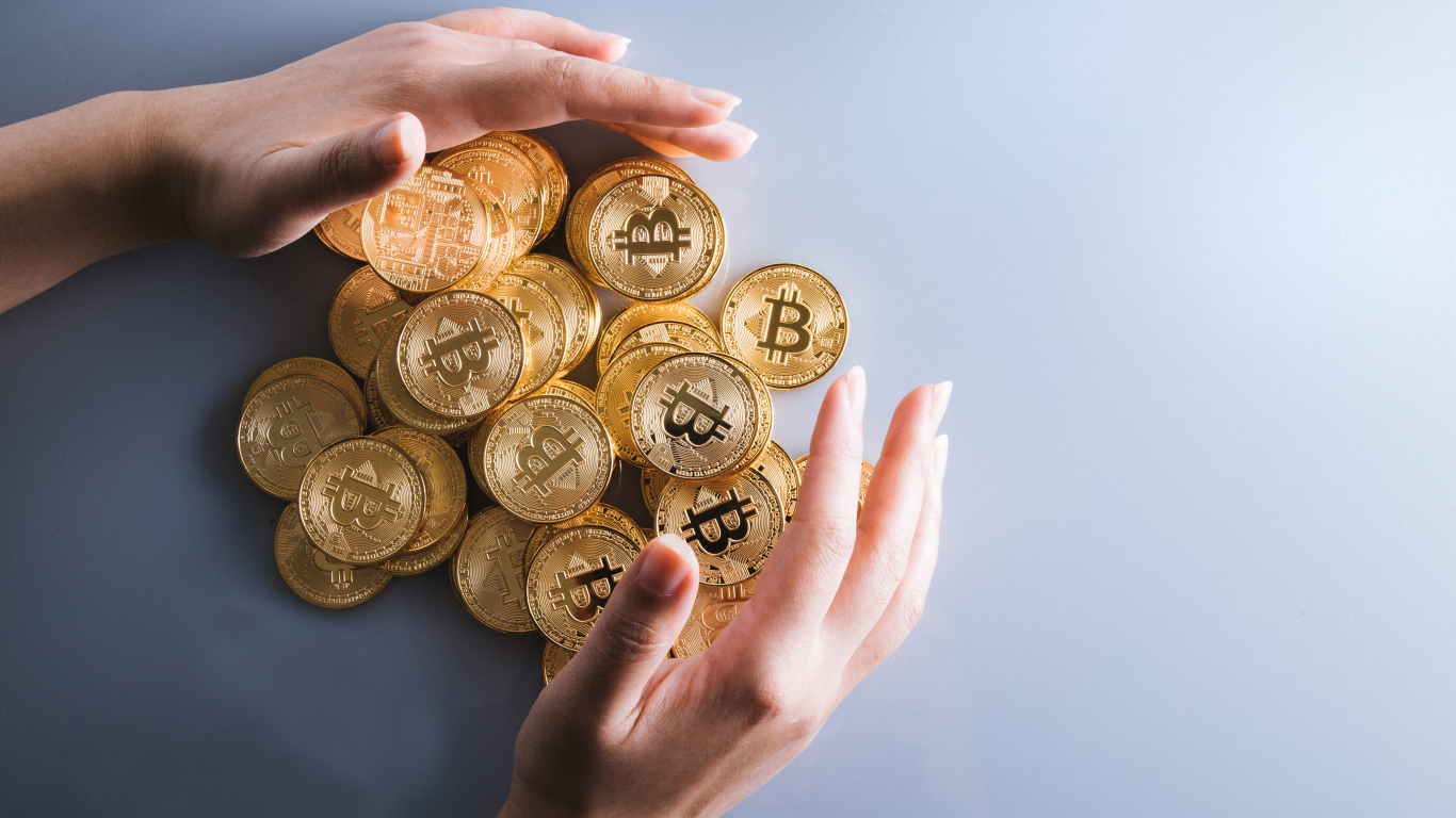 Много монет биткоин с руками на сером фоне