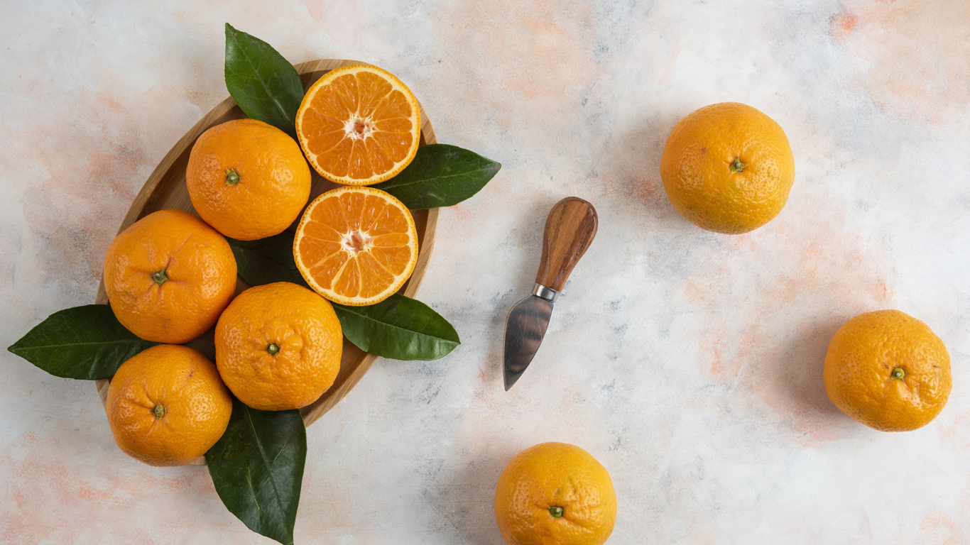 Крупные апельсины на столе с ножом