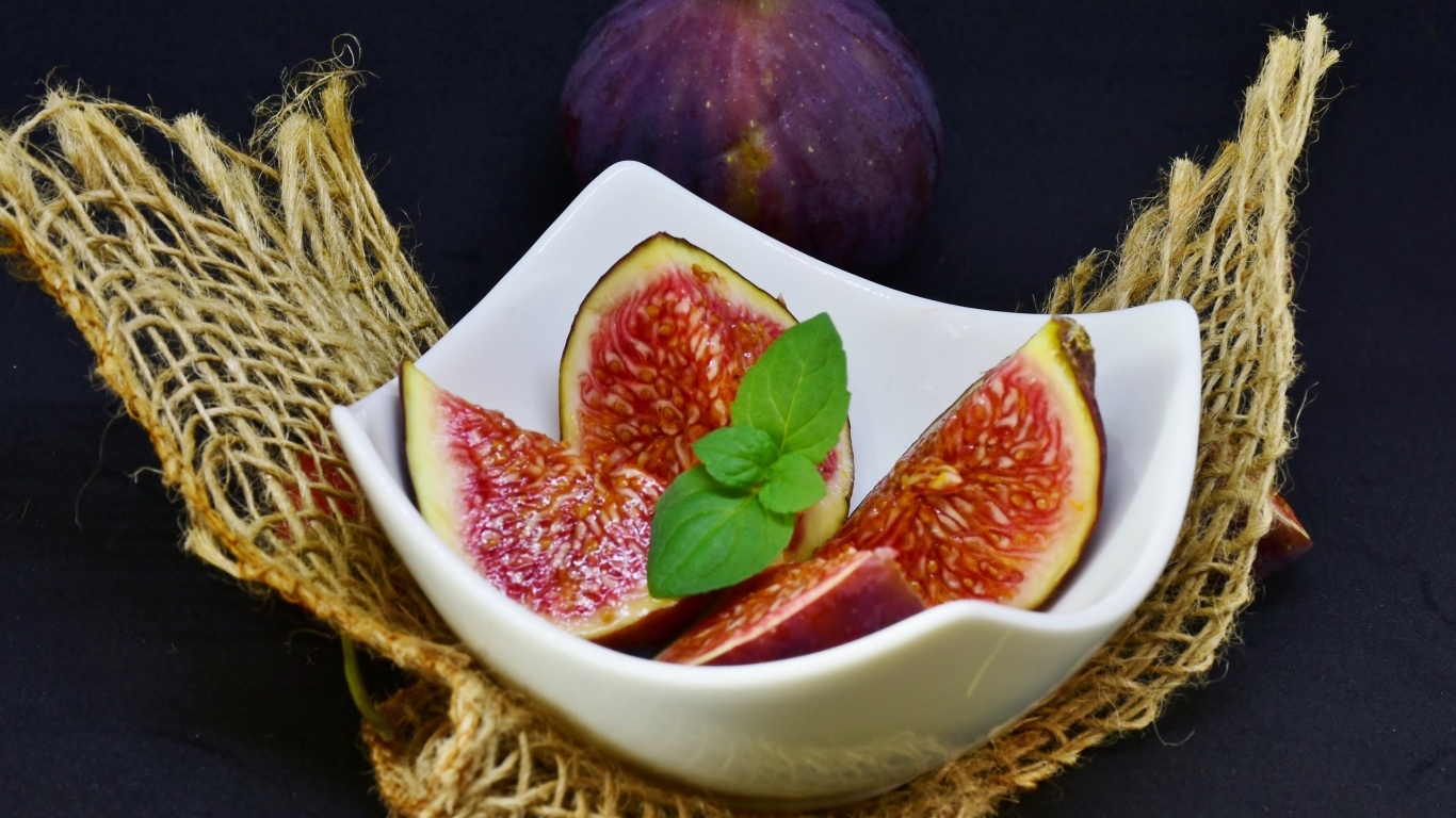 Нарезанный инжир в белой тарелке 