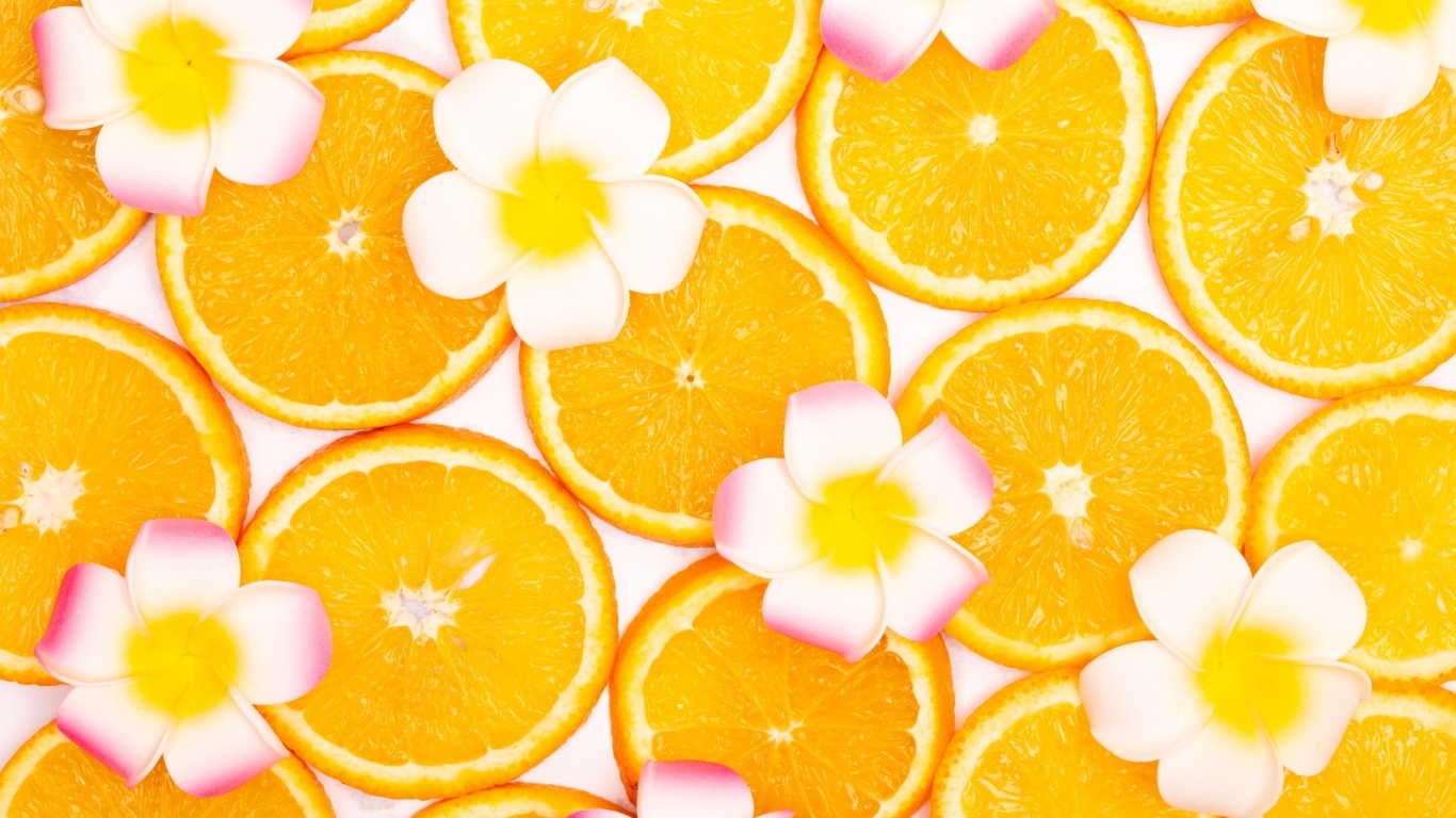 Нарезанный апельсин с цветами плюмерии для фона