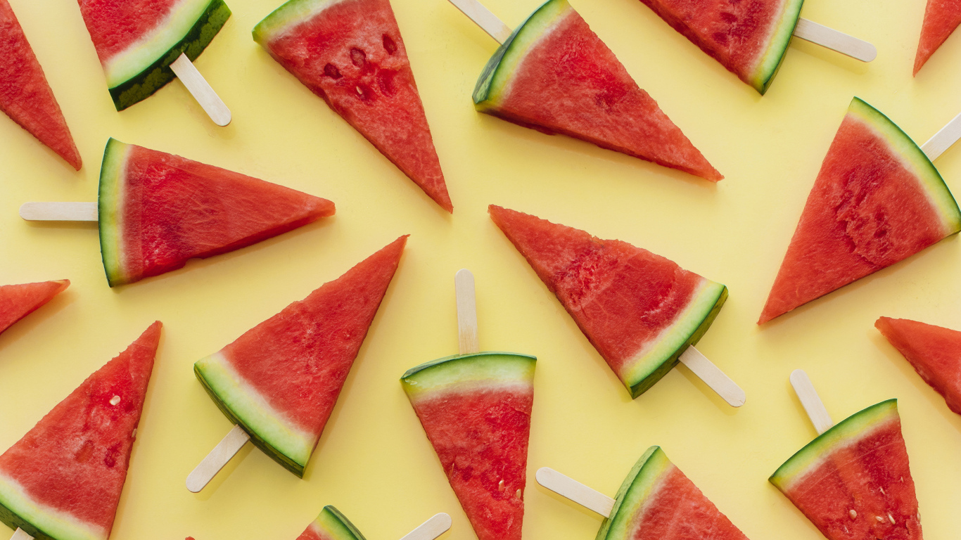 Куски арбуза на палочке на желтом фоне