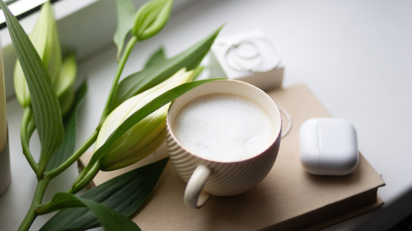 Чашка кофе на подоконнике с цветами лилии 