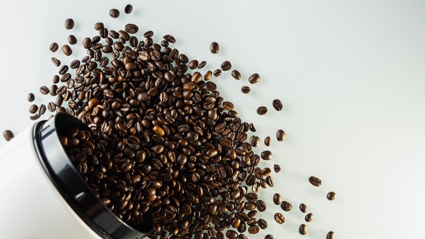 Много кофейных зерен на сером столе