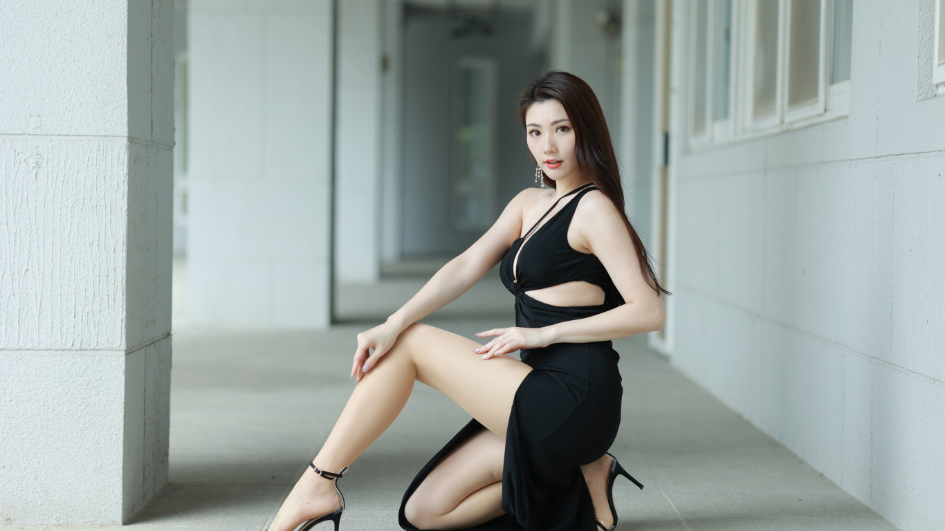 Девушка азиатка в черном наряде позирует для фото