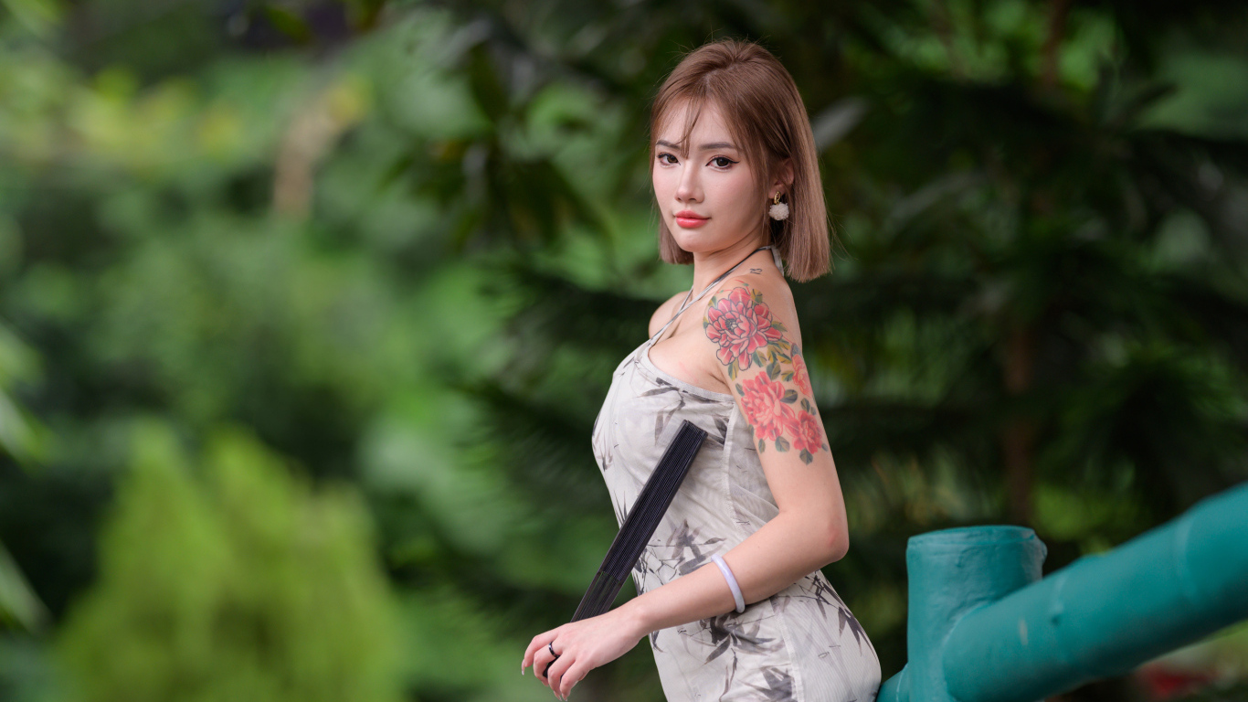 Красивая девушка азиатка с татуировкой на руке