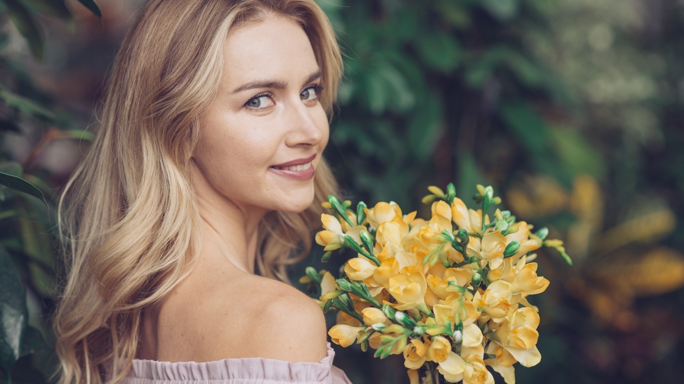 Милая девушка с букетом желтых цветов в руках