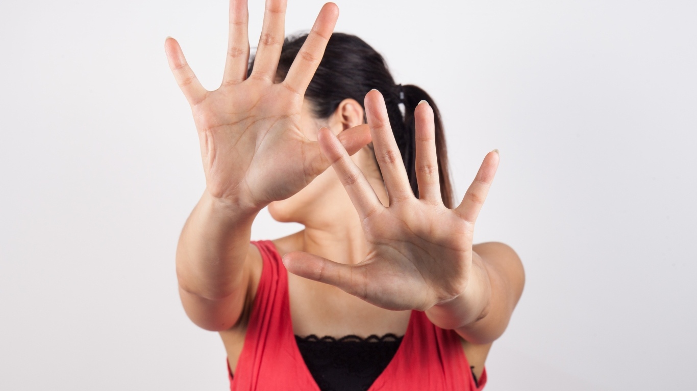 Девушка закрывает лицо руками