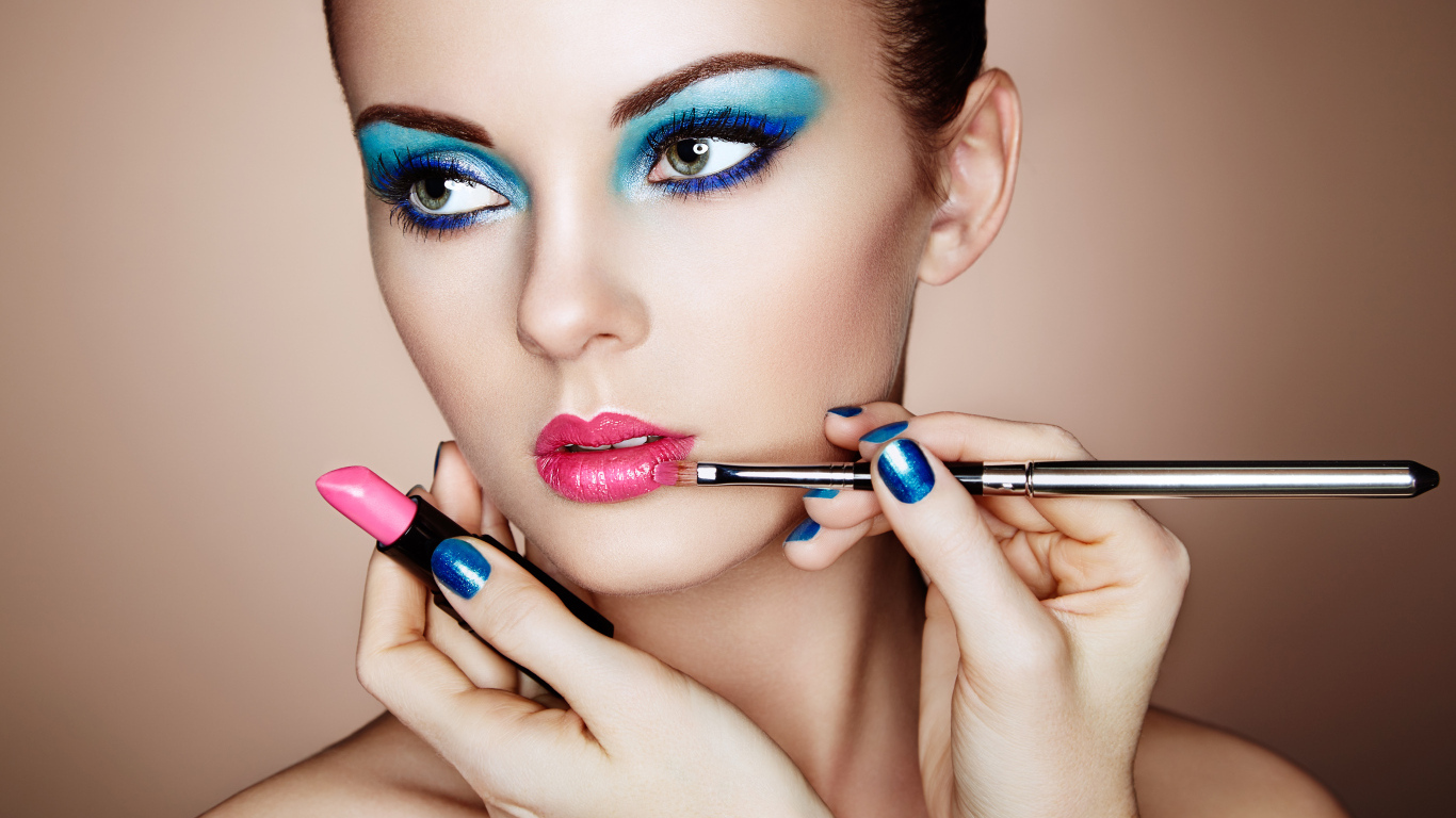 Девушке делают красивый яркий макияж