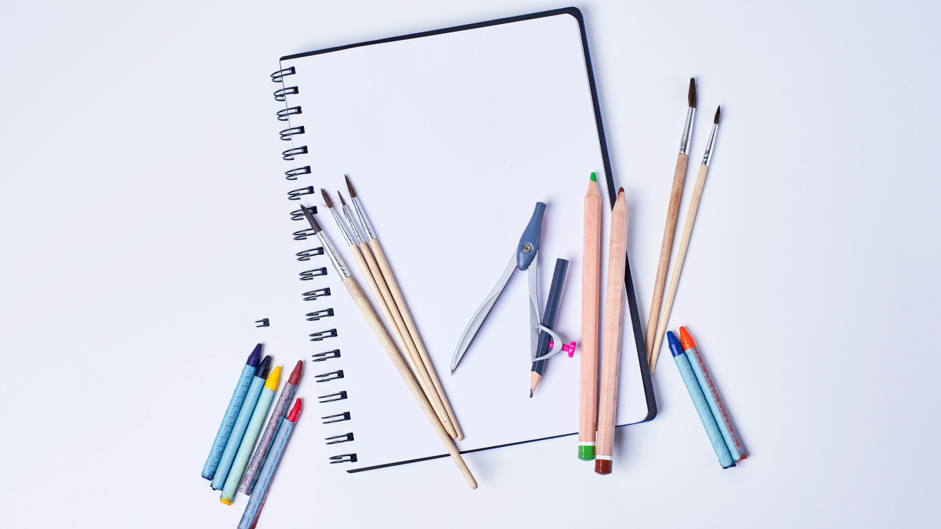 Карандаши, кисти и блокнот для рисования на сером фоне