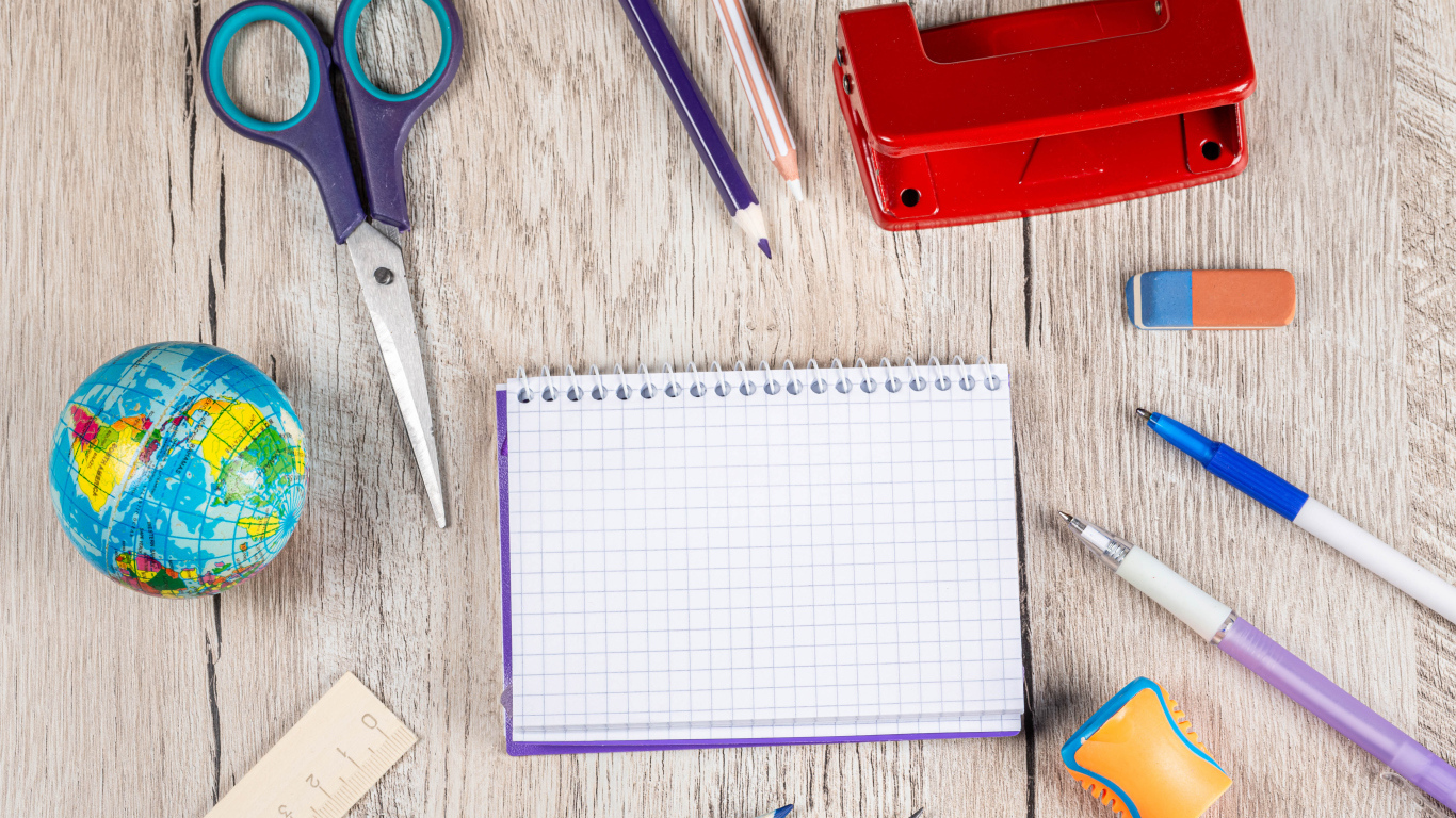 Канцелярские предметы, блокнот и глобус на деревянном столе