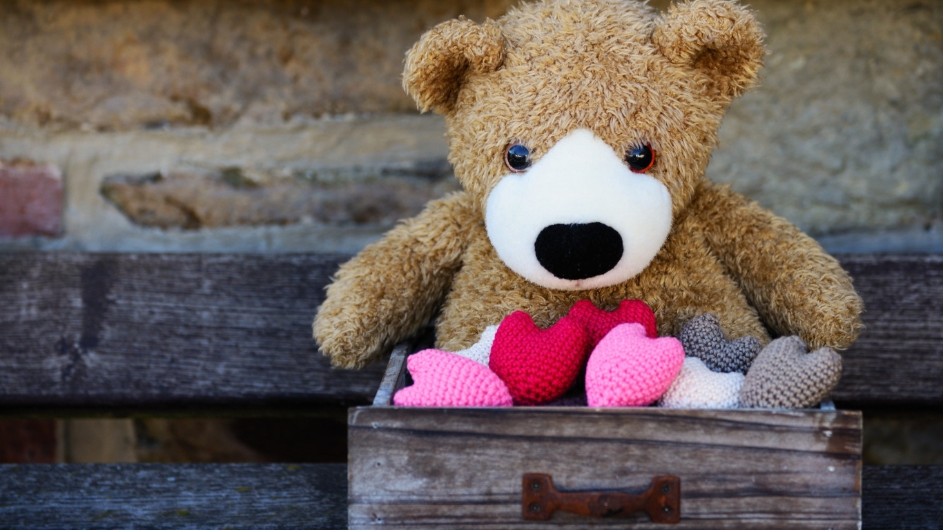 Игрушечный медвежонок с сердечками в деревянном ящике