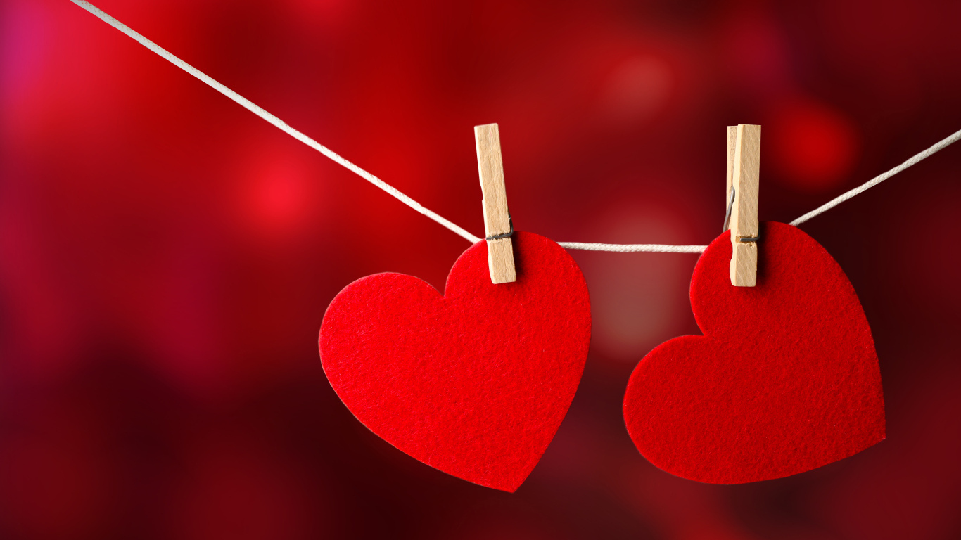 Два красных сердца висят на веревке