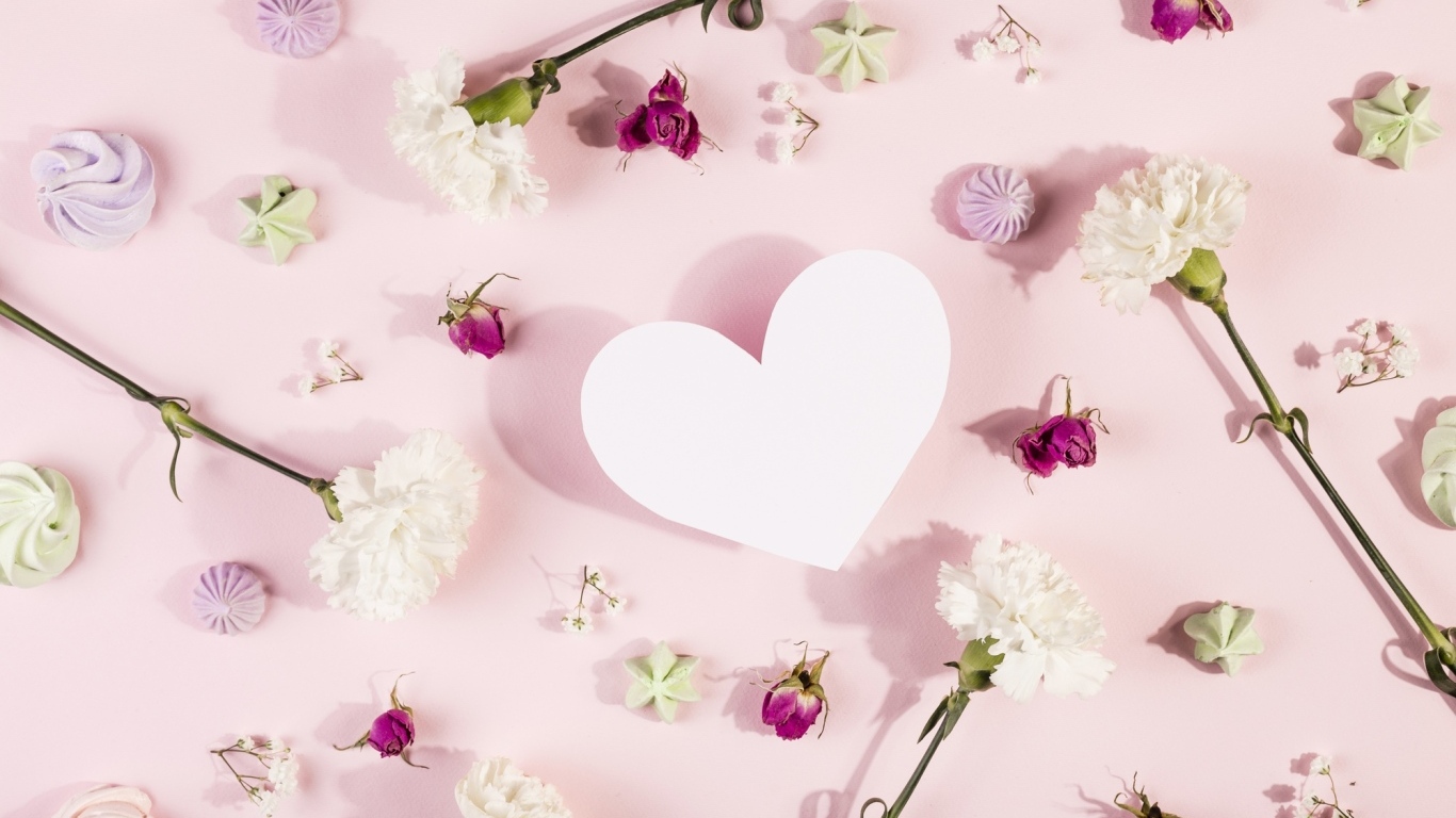 Белое бумажное сердце на розовом фоне с цветами