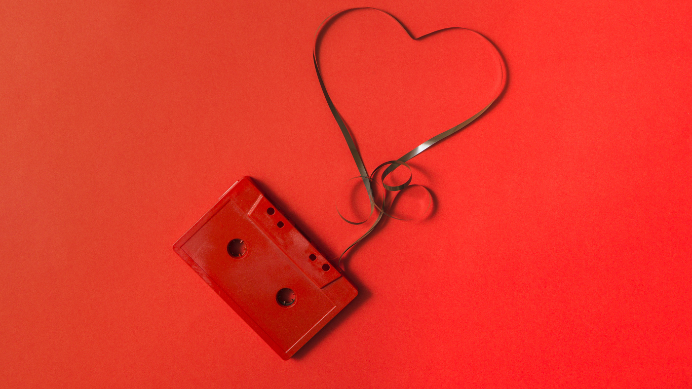 Кассета с сердцем из ленты на красном фоне