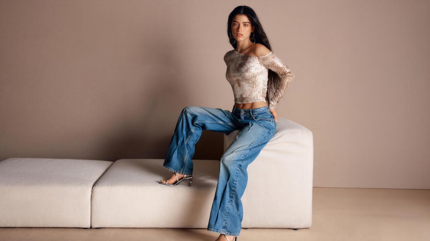 Знаменитая певица Дикси Дамелио в джинсах у дивана