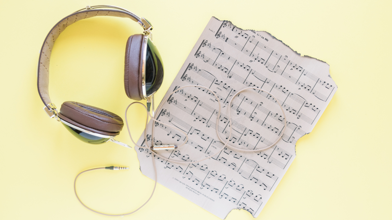 Старые ноты и наушники на желтом фоне