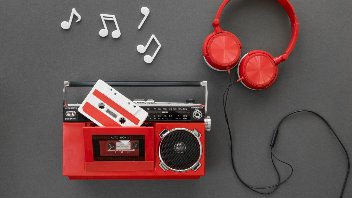 Магнитофон с кассетой, наушниками и нотами на сером фоне