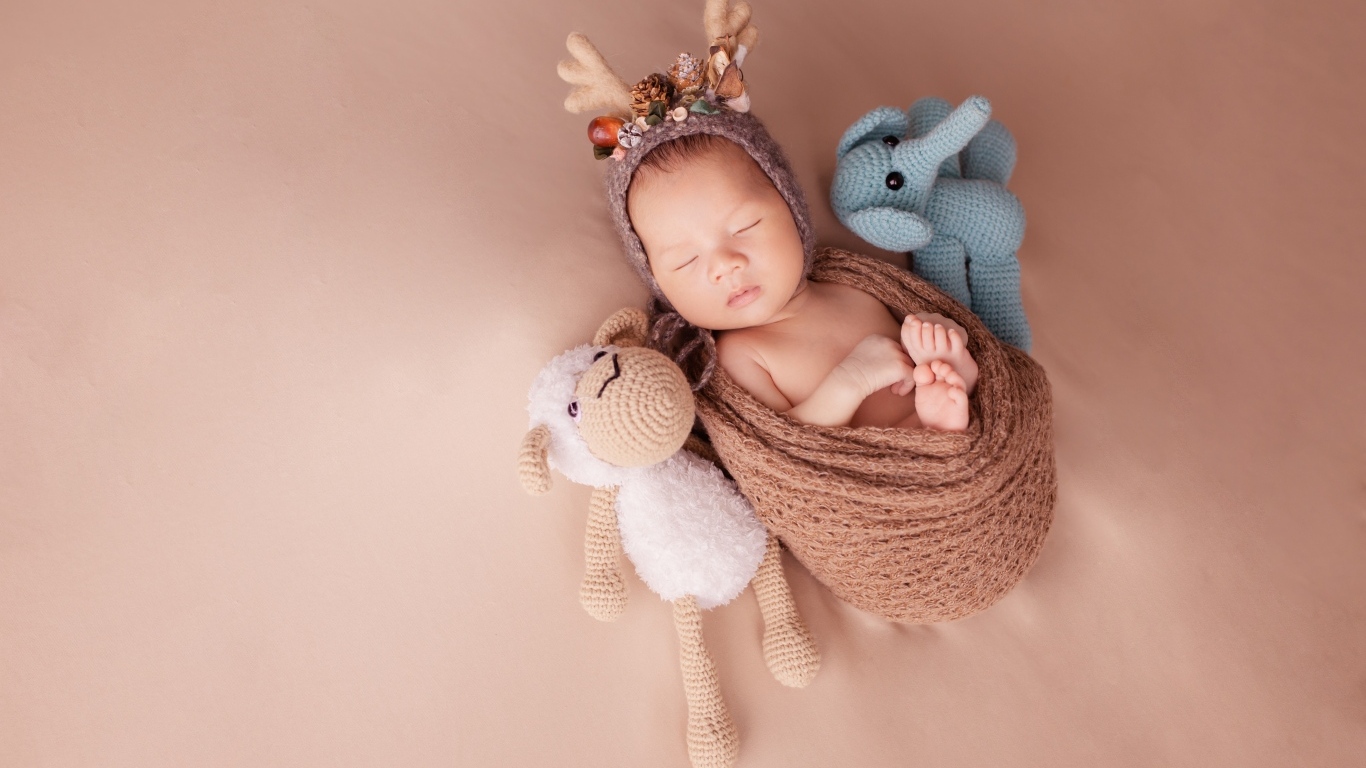 Маленький ребенок в костюме оленя с игрушкой