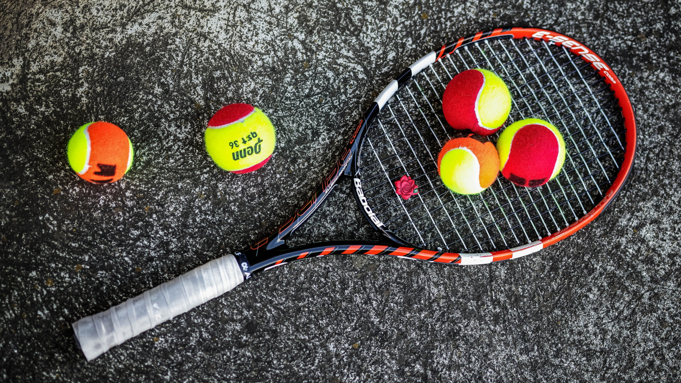 Ракетка и теннисные мячи на черном фоне