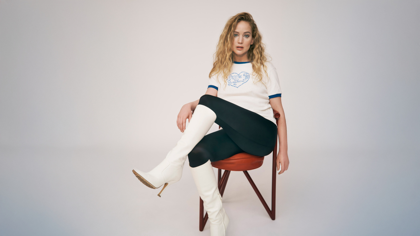 Актриса Дженнифер Лоуренс сидит на стуле на сером фоне