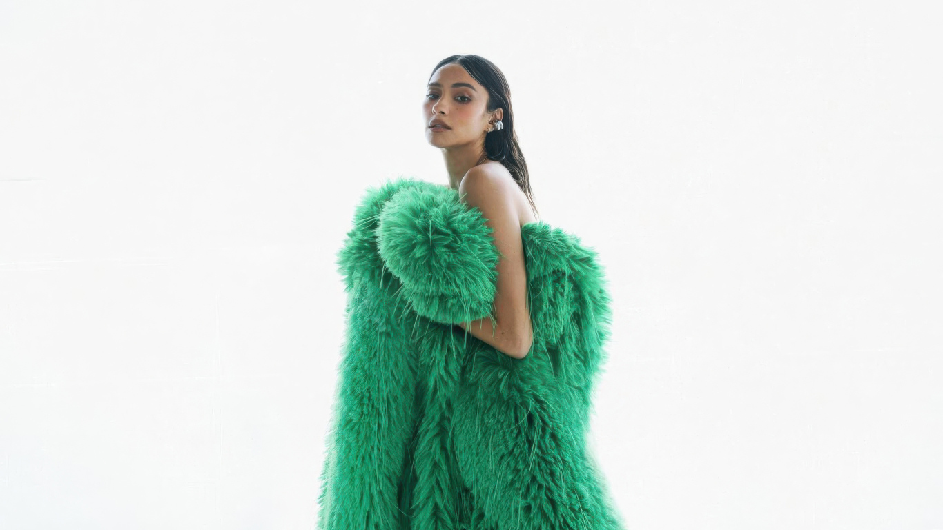 Актриса Шэй Митчелл в зеленой шубе на белом фоне
