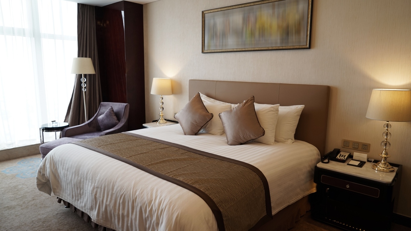 Большая кровать в комнате с картиной на стене