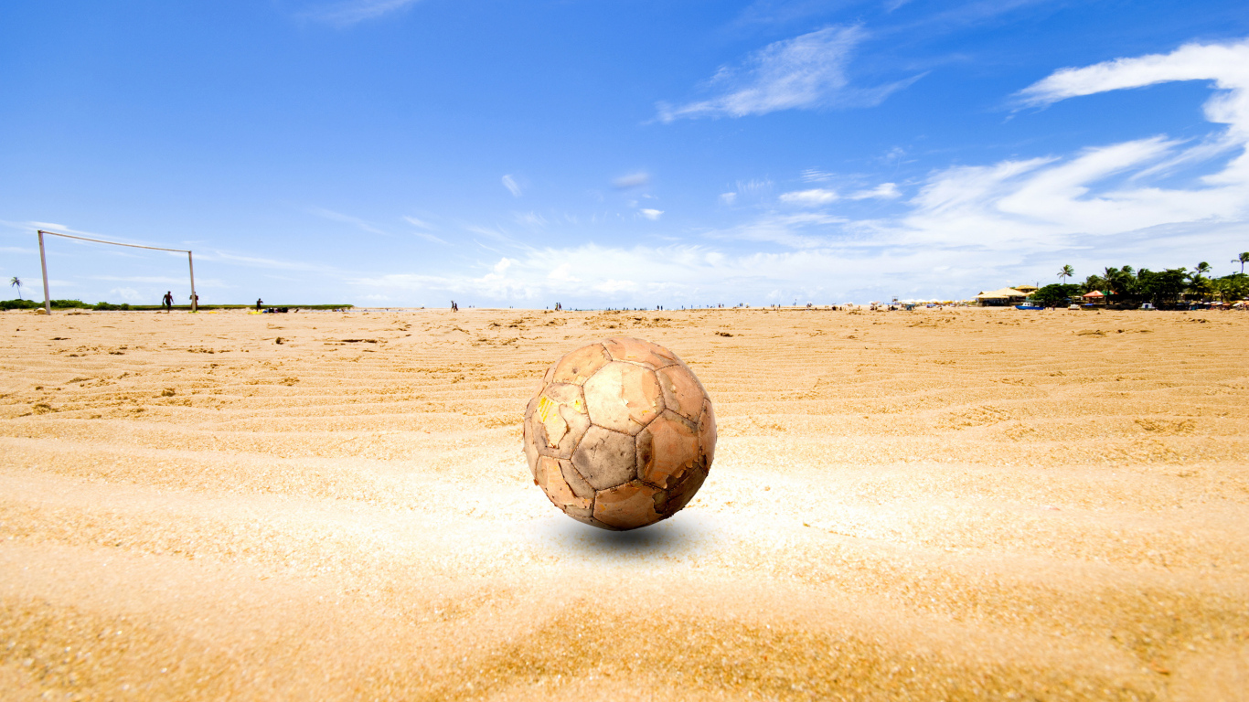 Старый футбольный мяч на песке