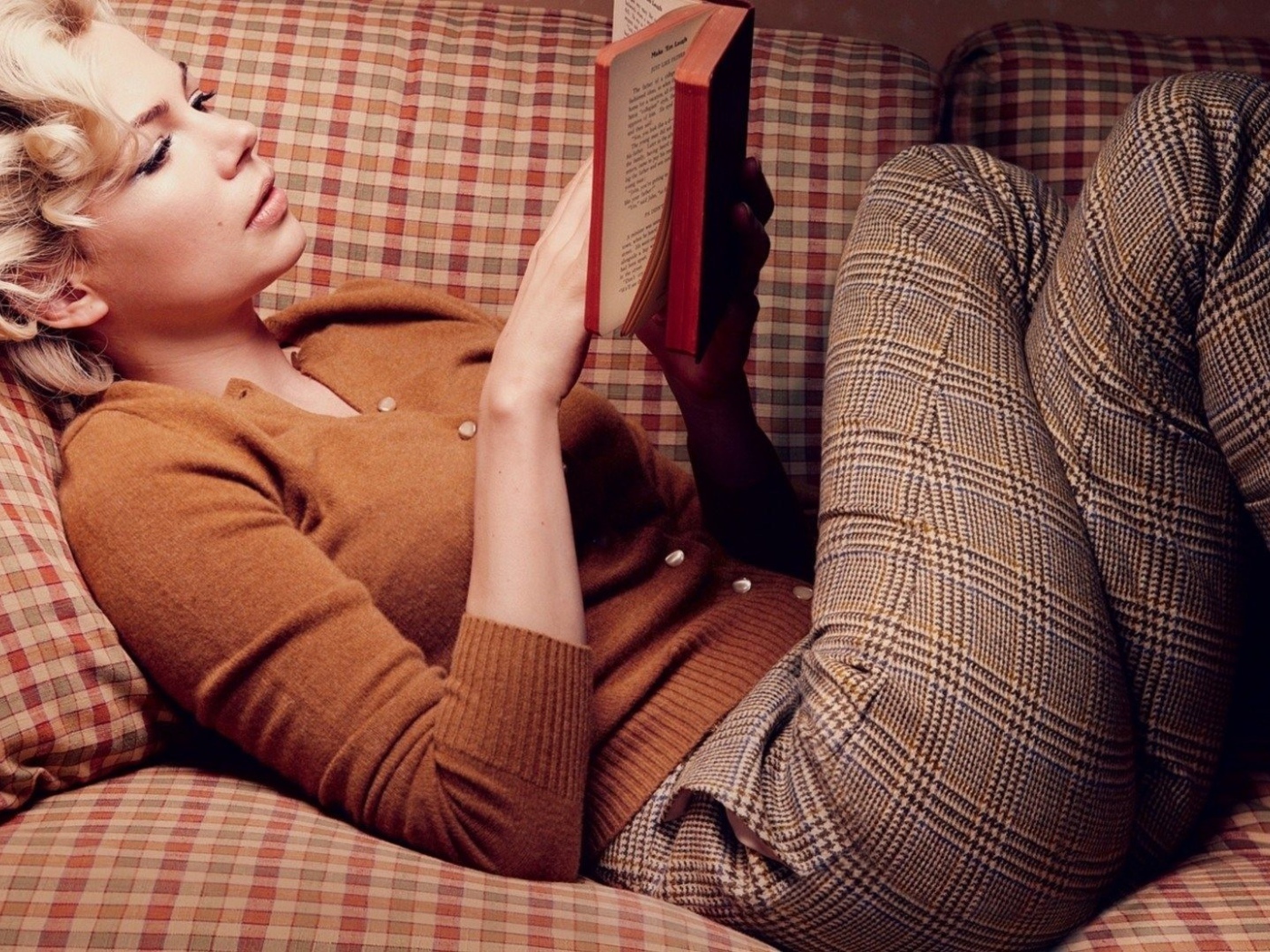 Girl reading a book lying on the couch