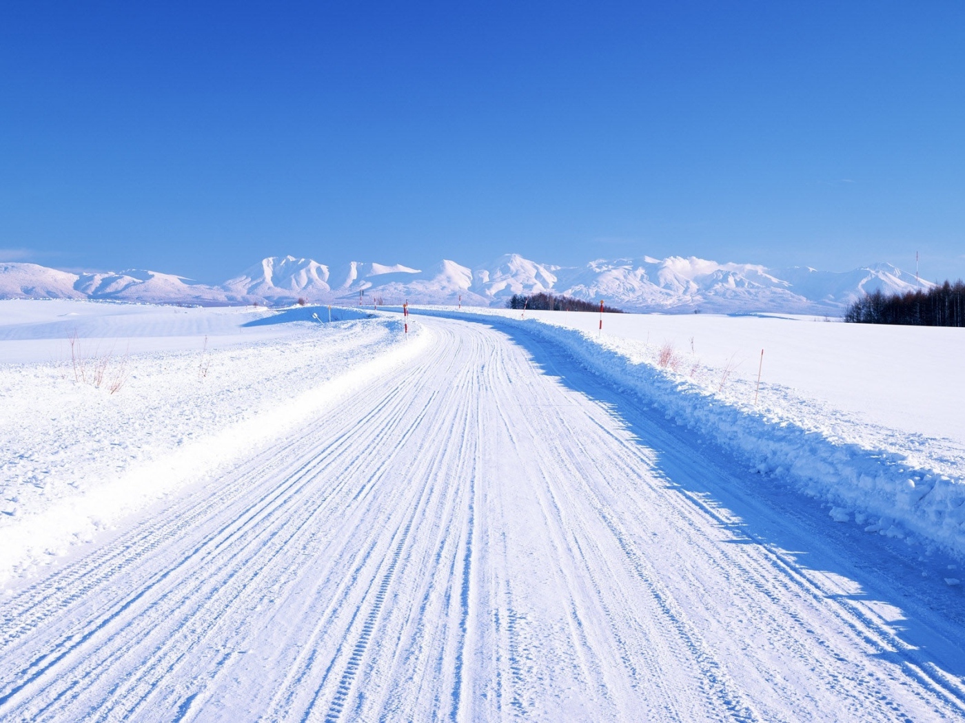 Зимняя дорога на фоне заснеженных гор