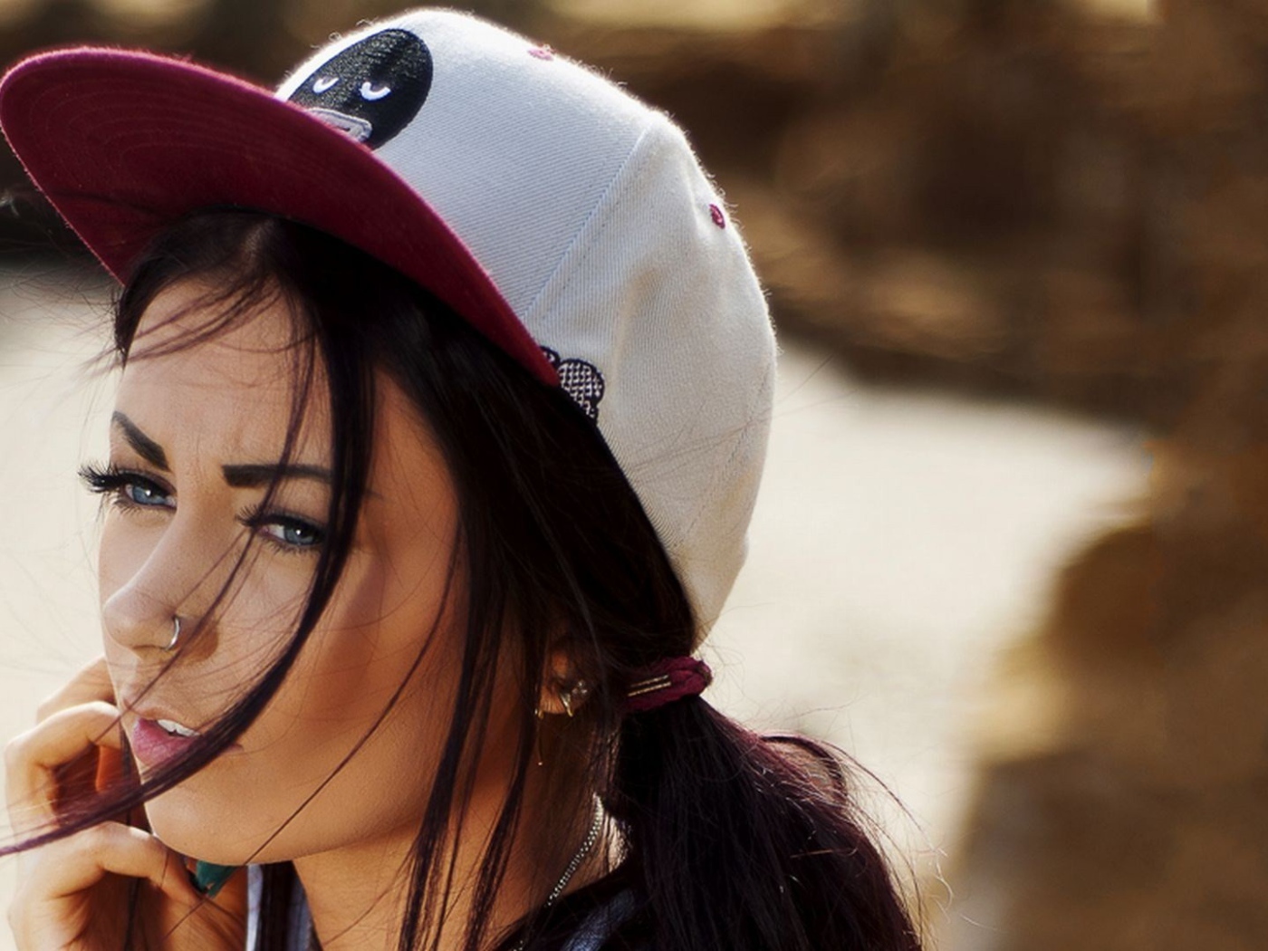 Девушка брюнетка в кепке и с пирсингом в носу