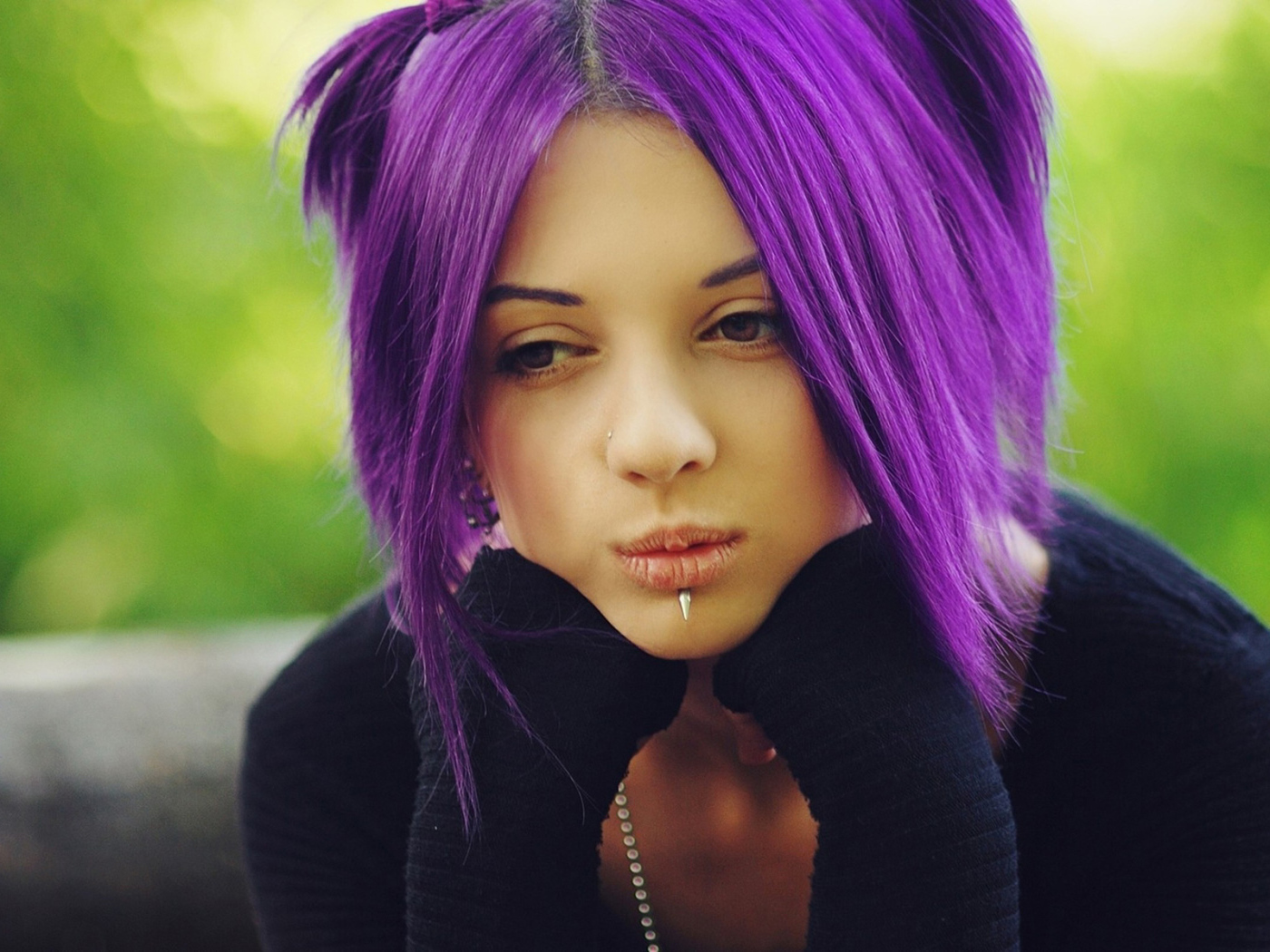 Молодая девушка с пирсингом в носу и губах