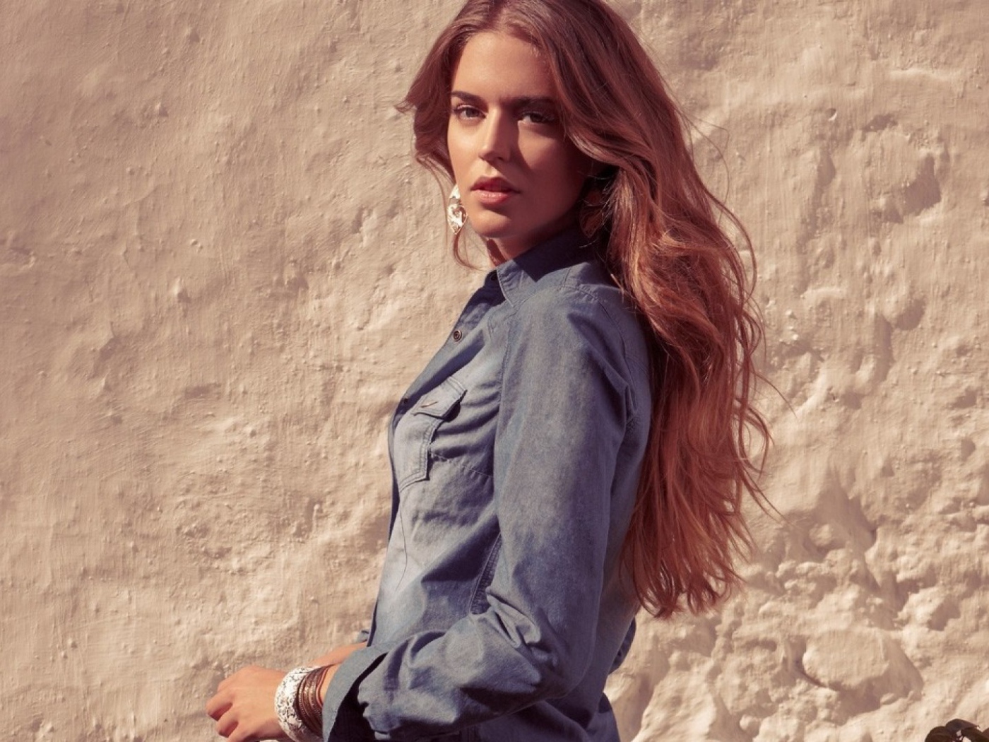 Красивая девушка на фоне песчанной стены