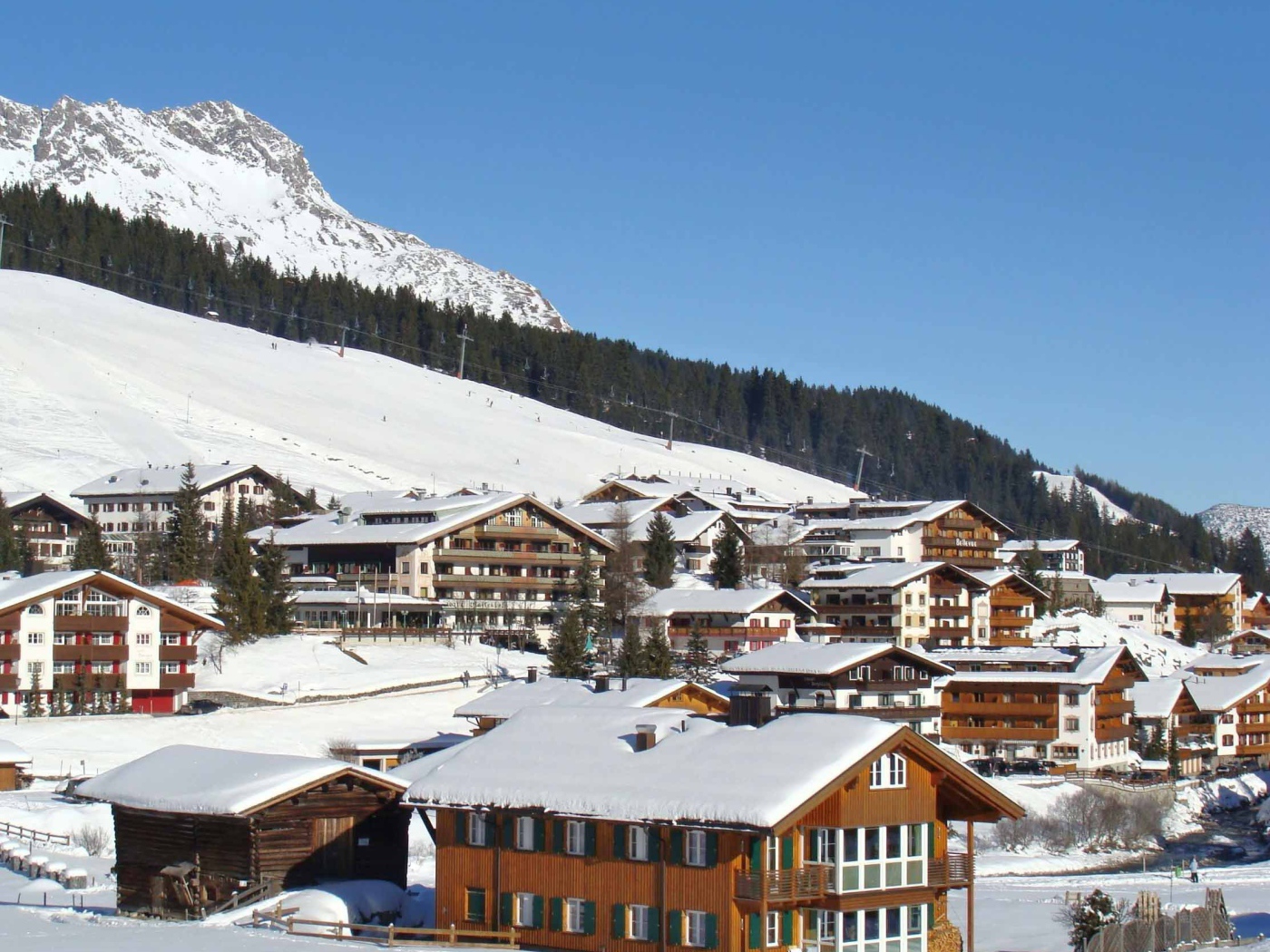 Дома на фоне гор на горнолыжном курорте Лех, Австрия