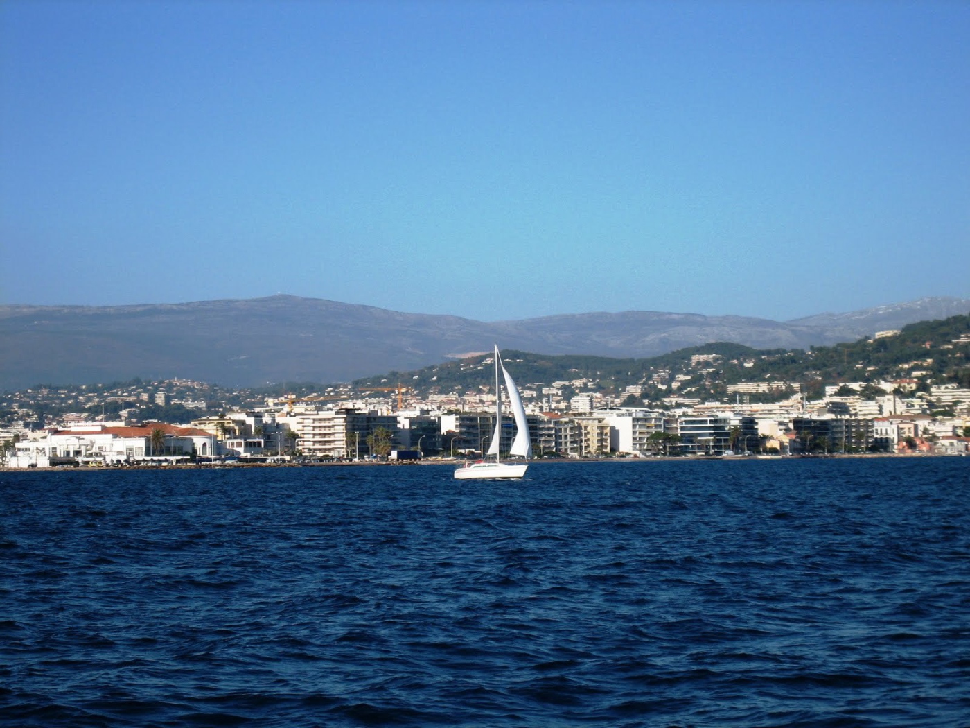 Яхта на фоне города на курорте Порт Де Фрежюс, Франция