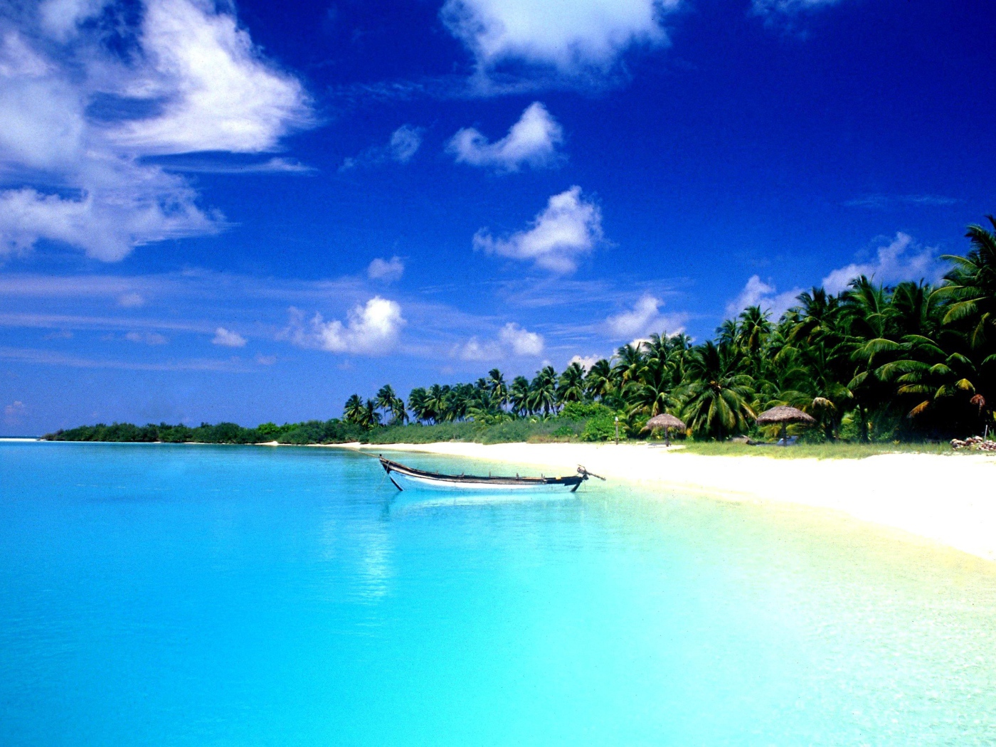 Белая лодка на лазурной воде в Гоа