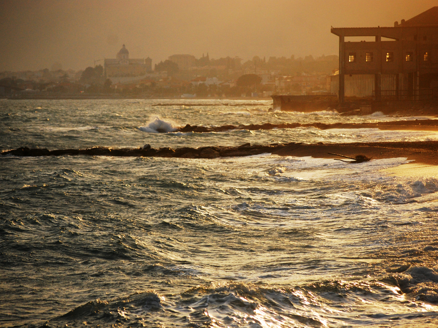 Закат на пляже на курорте в Пьетра Лигуре, Италия