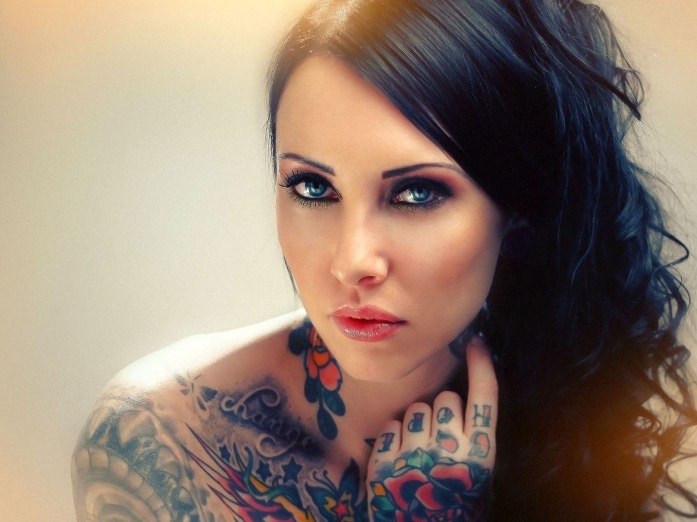 Голубоглазая девушка с татуировкой на руке и плече