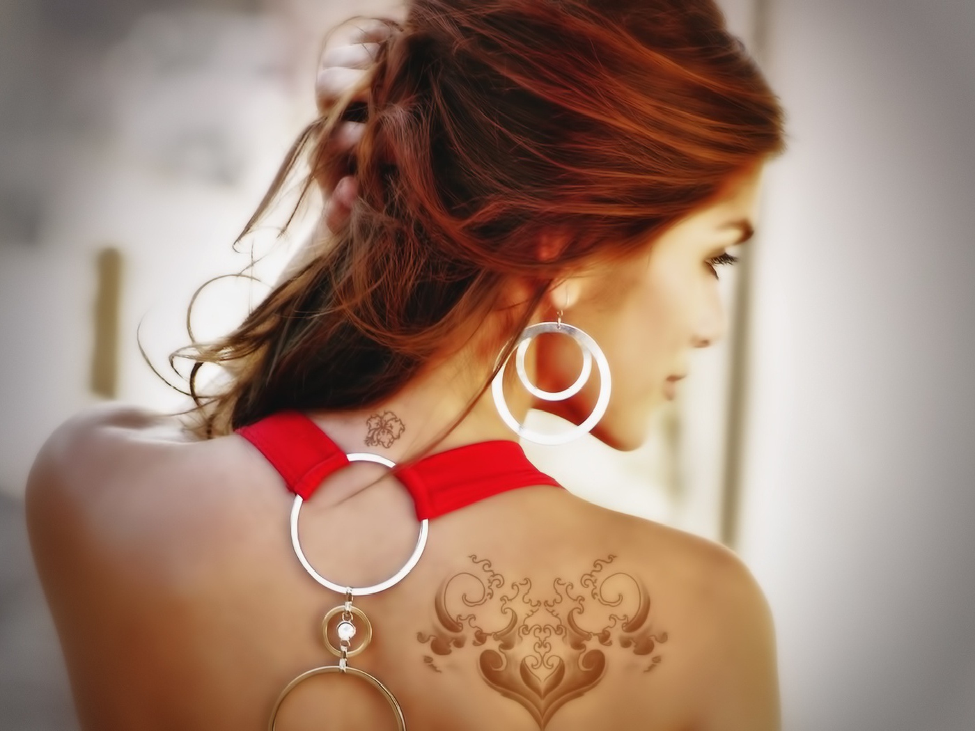 Девушка с татуировками на плече и шее